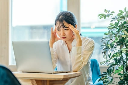 頭痛の辛い症状で仕事に集中できず悩む女性